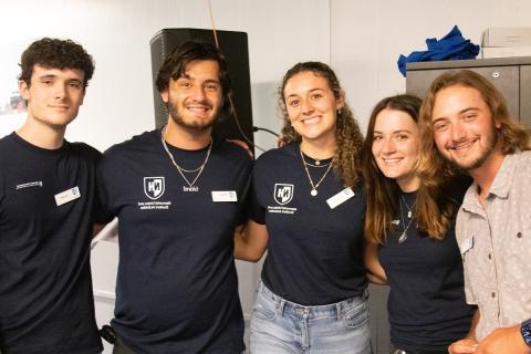 Five MUB employees wearing MUB t-shirts posing together