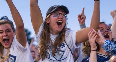 Fans cheering outside at a UNH football game