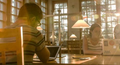 UNH Students studying on laptops at table in library