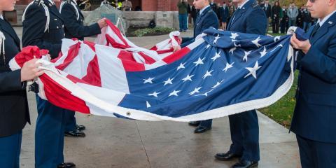 members of the military holding an American flag