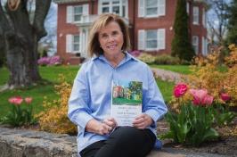 简·迪恩拿着她的书坐在总统的房子外面