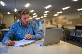 保罗学院在线MBA在他的笔记本电脑上看课程作业